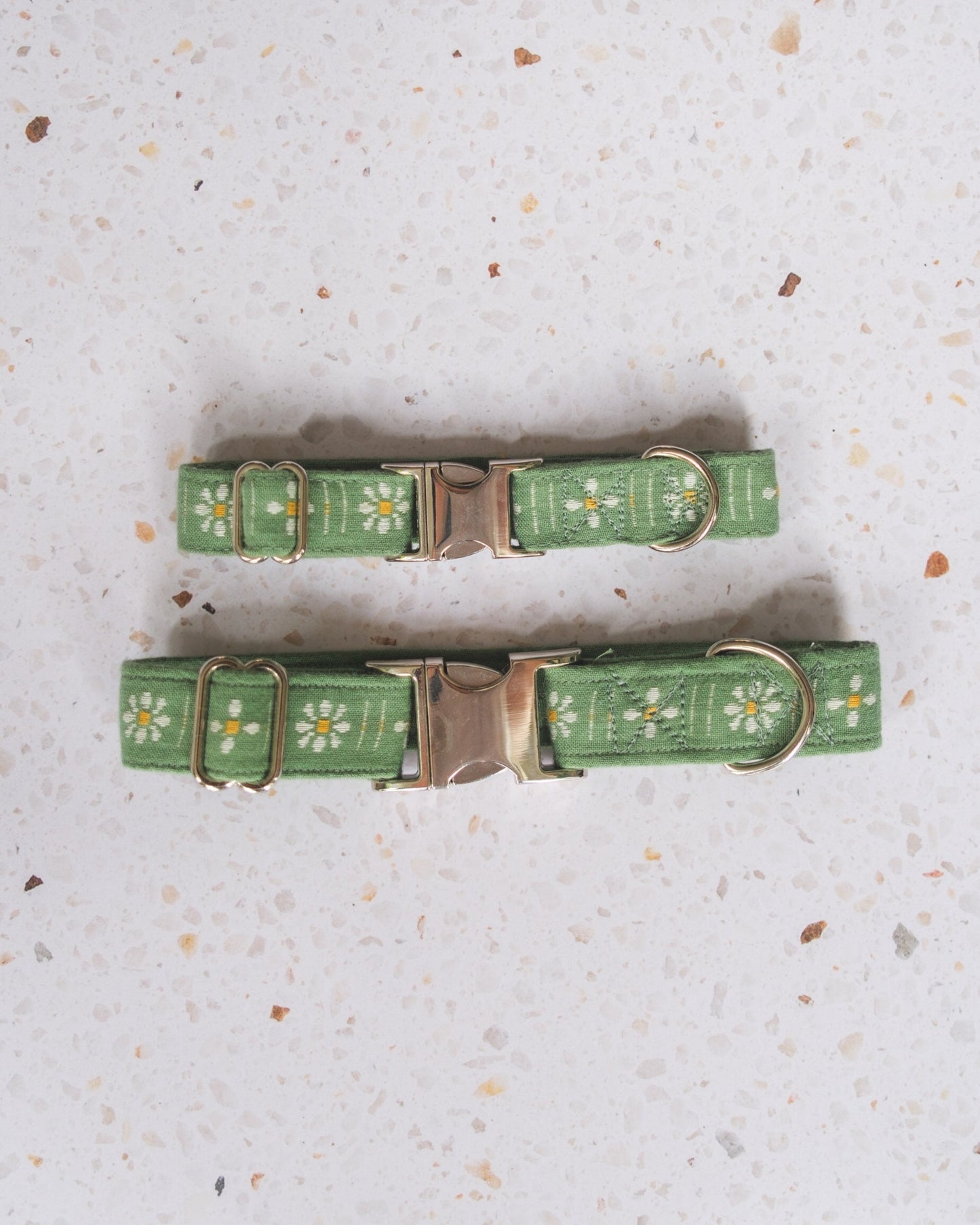 Green floral-patterned dog collar on a textured gray surface