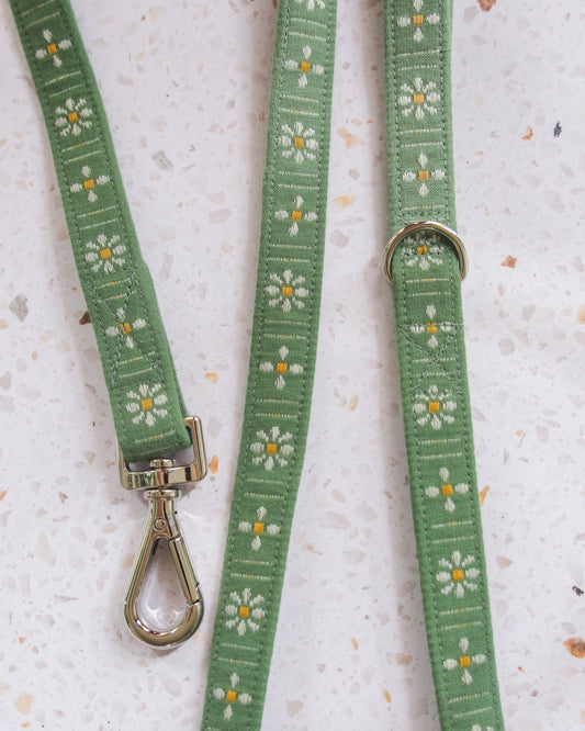 Green dog leash with floral pattern on a textured surface