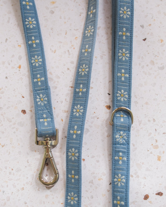 Blue dog leash with floral pattern on a textured surface