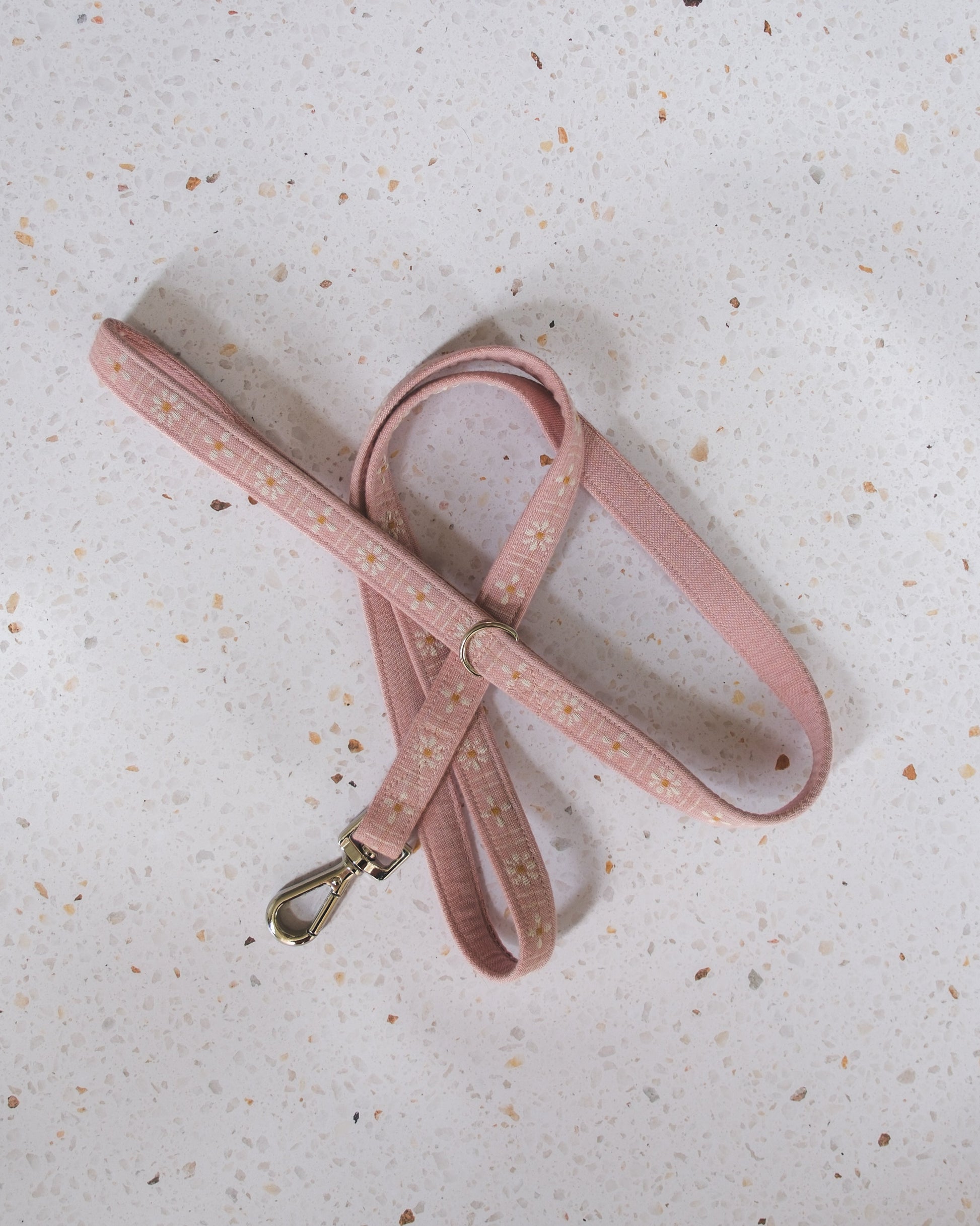 Pink dog leash on a textured light gray surface