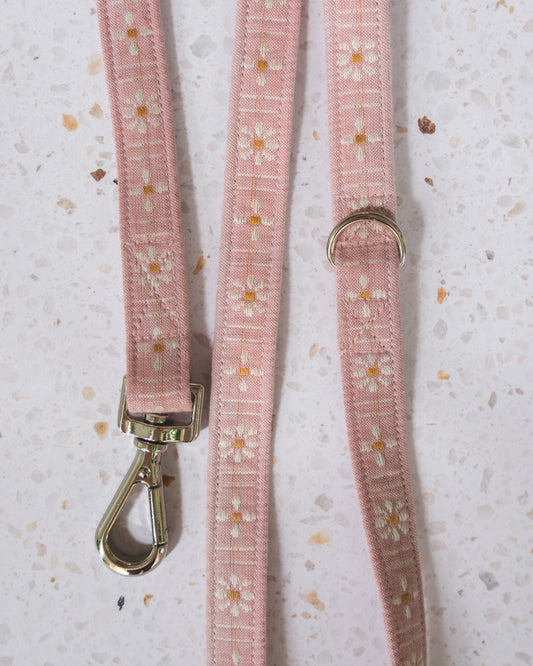 Pink dog leash with floral pattern on a light gray background